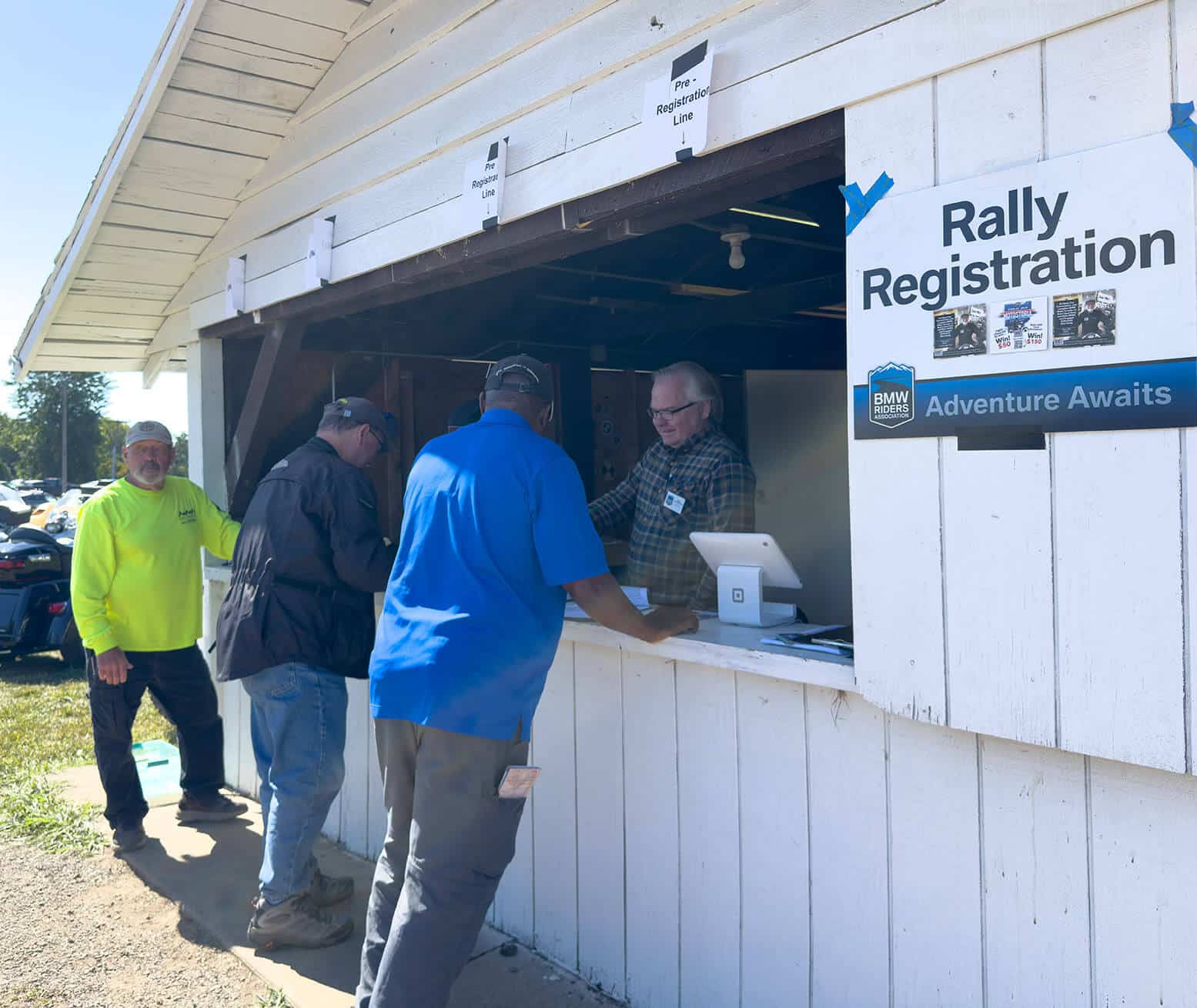 Three attendees registering at a BMW Riders rally